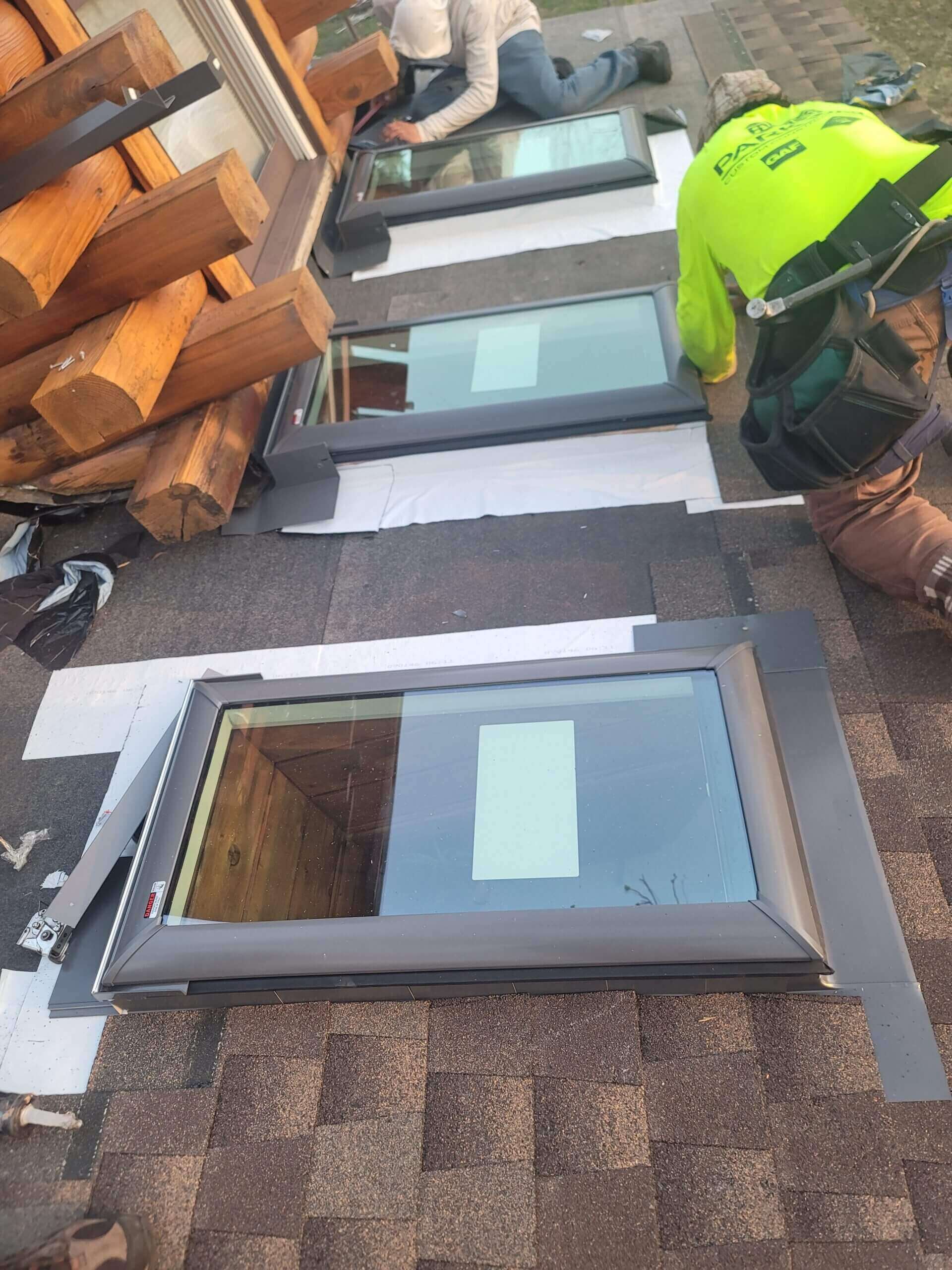 Roof workers installing skylight windows.